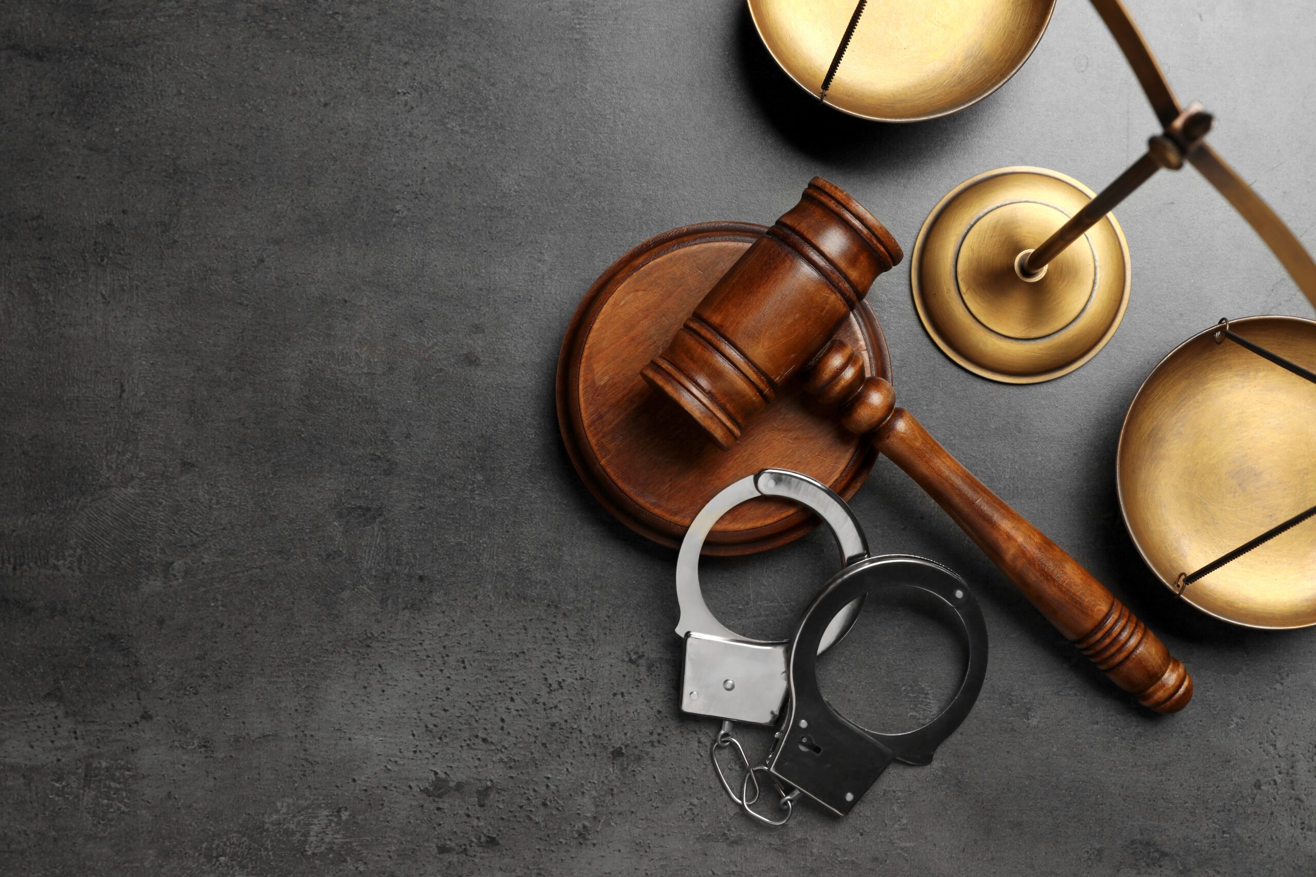 Judge's gavel, handcuffs and scales on grey background, flat lay with space for text. Criminal defense lawyer Michael Fayard Judge's gavel, handcuffs and scales on grey background, flat lay with space for text. Criminal defense lawyer Michael Fayard